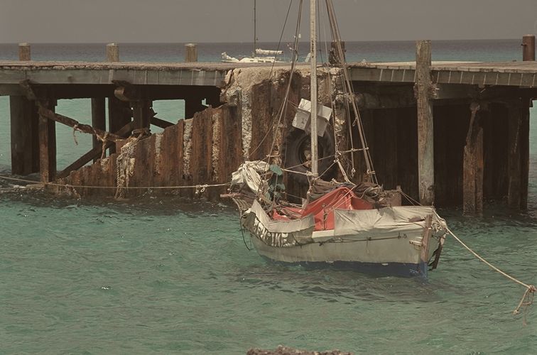 Small boat beside an old pier