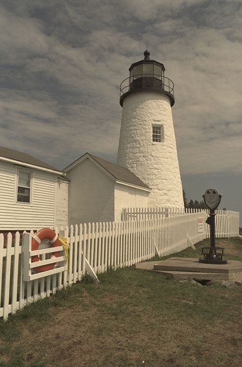 White lighthouse behind a picket fence